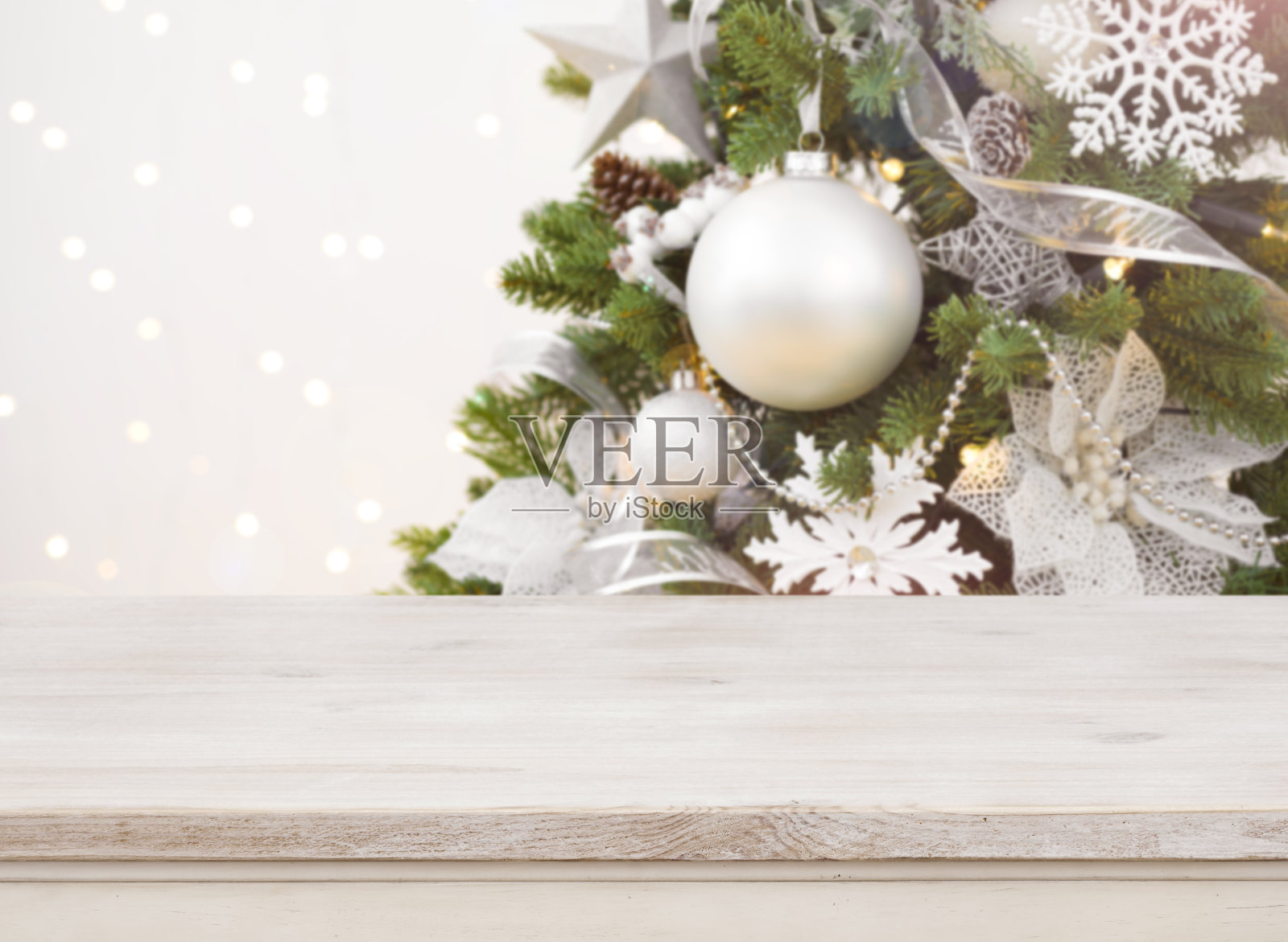 木制桌子前模糊装饰圣诞树的背景照片摄影图片
