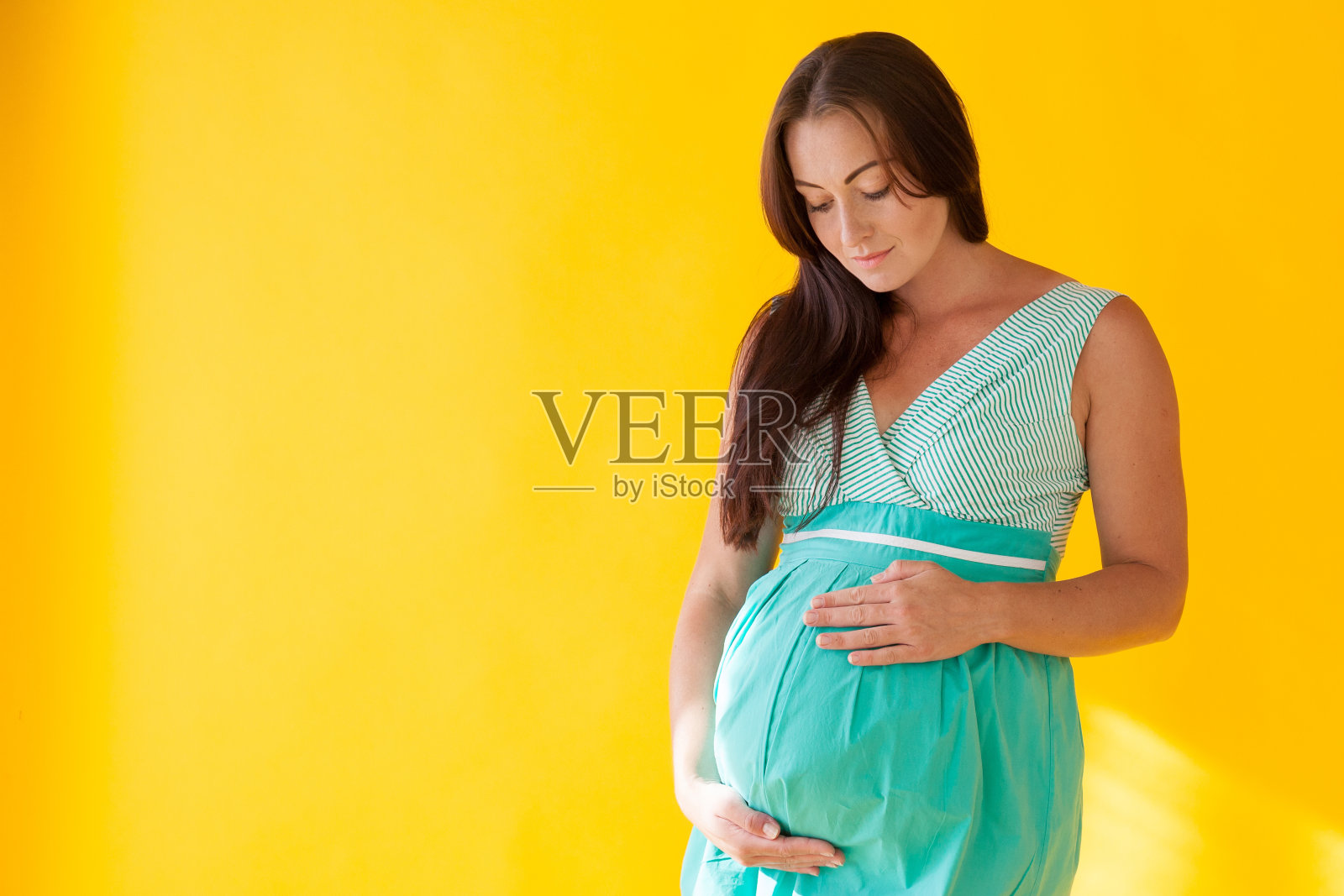 孕妇分娩前背景为黄色照片摄影图片