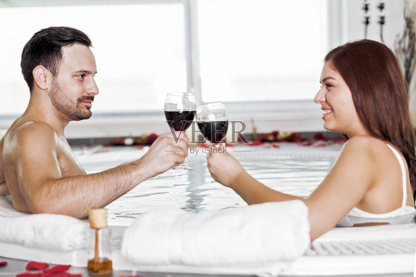 一对夫妇在热水浴缸里喝葡萄酒照片摄影图片