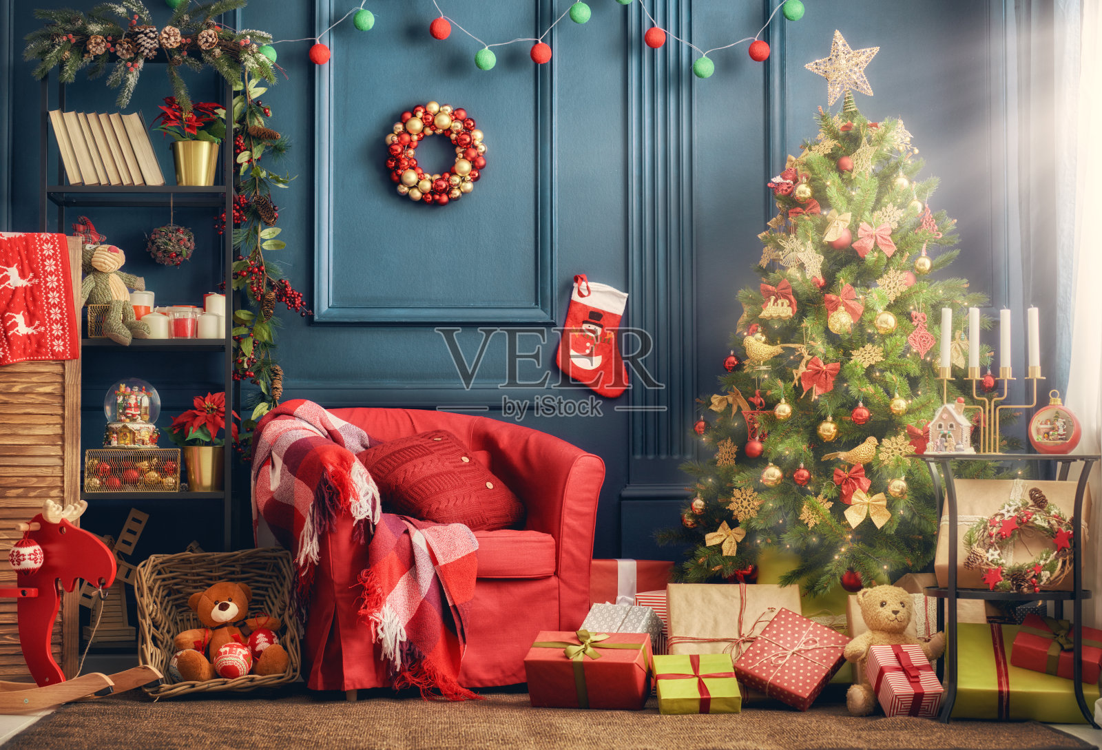 圣诞房间室内设计，圣诞树的灯光装饰提出了礼品玩具、 壁炉和蜡烛照明在室内高清摄影大图-千库网