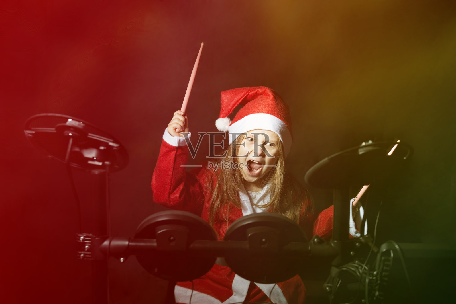 小鼓手装扮成圣诞老人打电子鼓包照片摄影图片