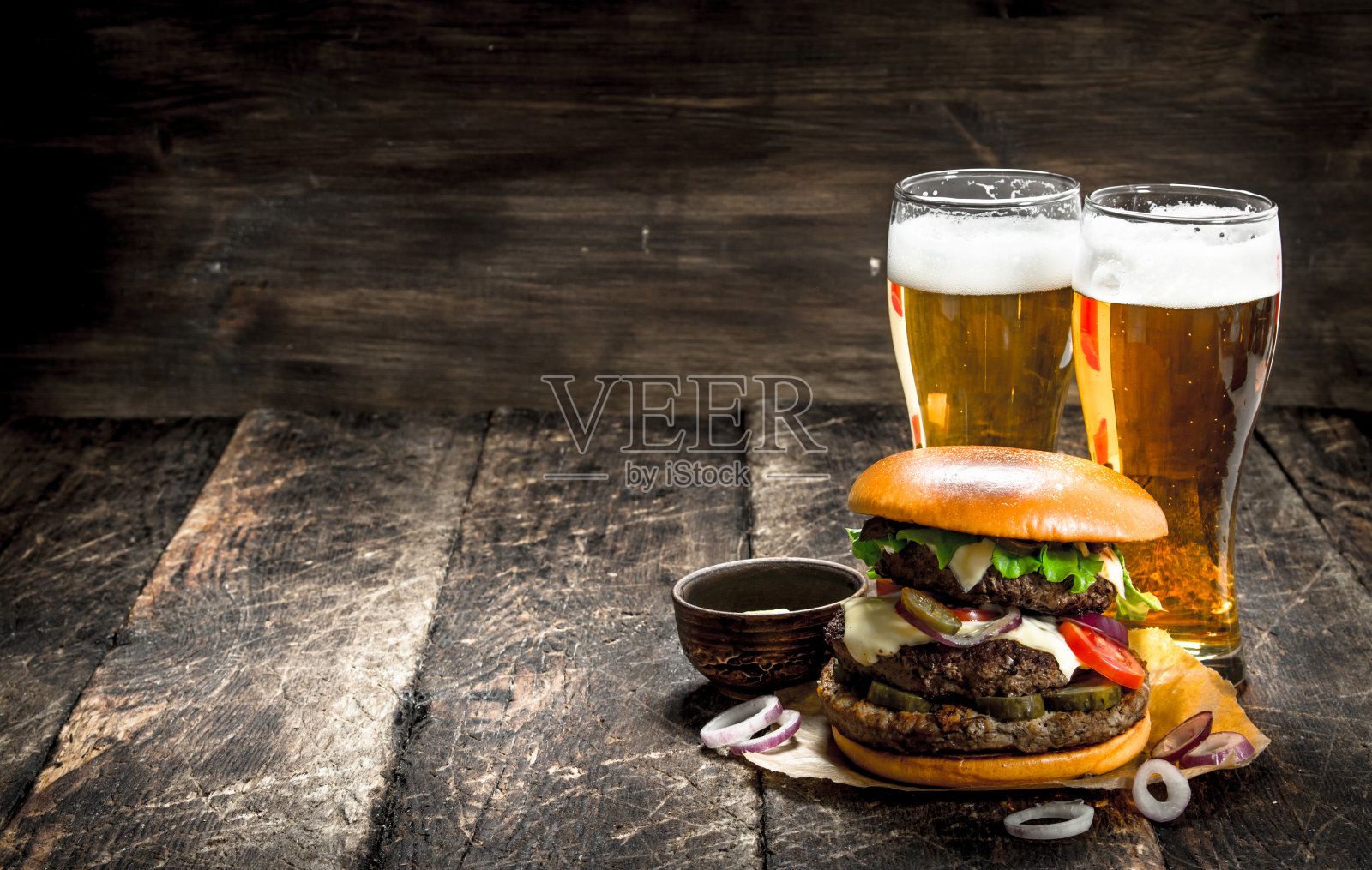 街头食品。一个大汉堡和几杯淡啤酒。照片摄影图片
