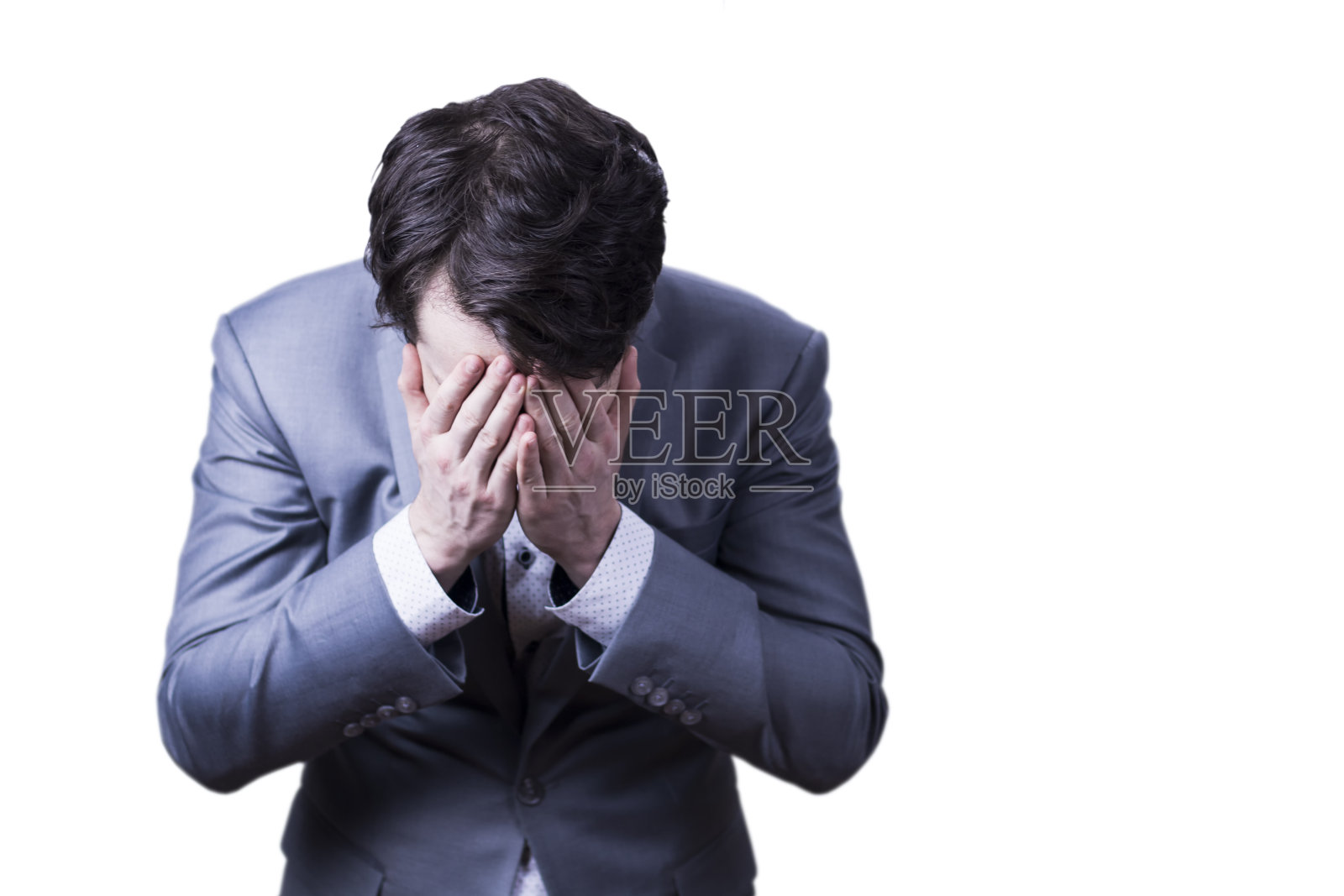 绝望的商人在灰色西装抱着他的头在悲伤的表情。照片摄影图片