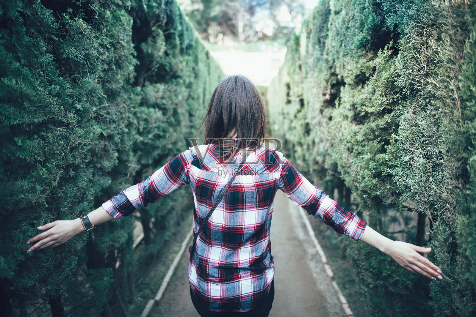 一个年轻女子走在公园的迷宫里照片摄影图片