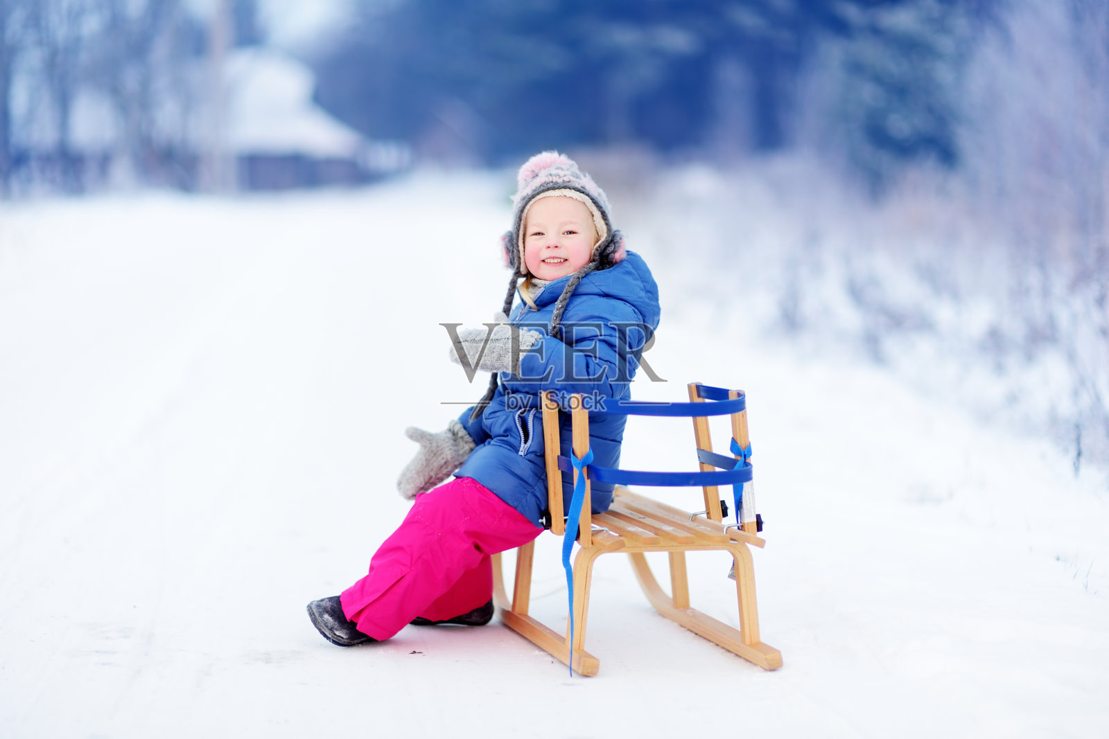 有趣的小女孩在冬季公园玩雪橇照片摄影图片