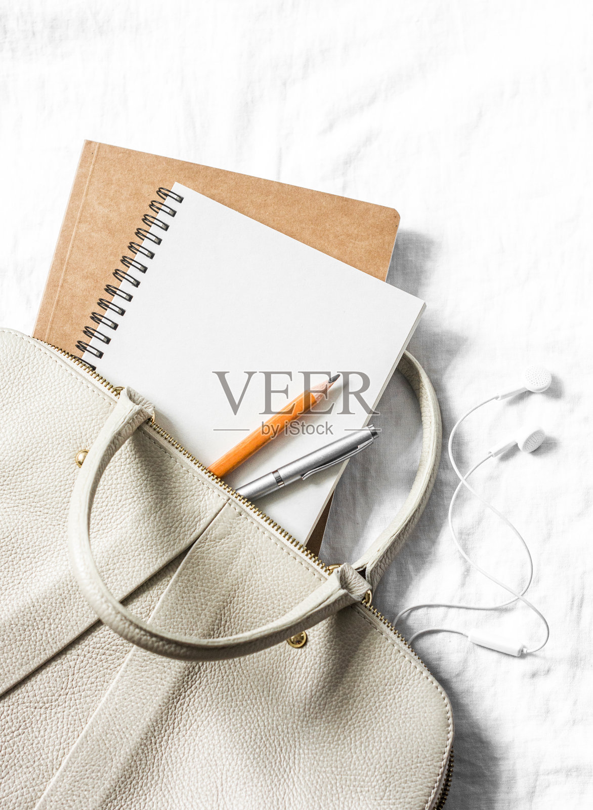 女式皮包，干净的空白记事本，笔上浅色背景，俯视图。文本的空闲空间照片摄影图片