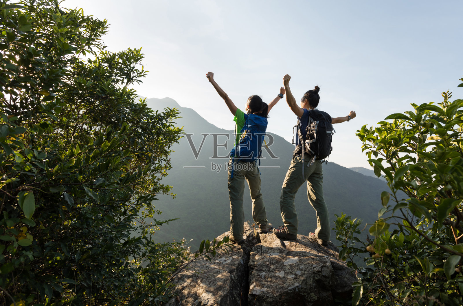 两个年轻的女性成功的背包客享受着悬崖边缘的景色照片摄影图片