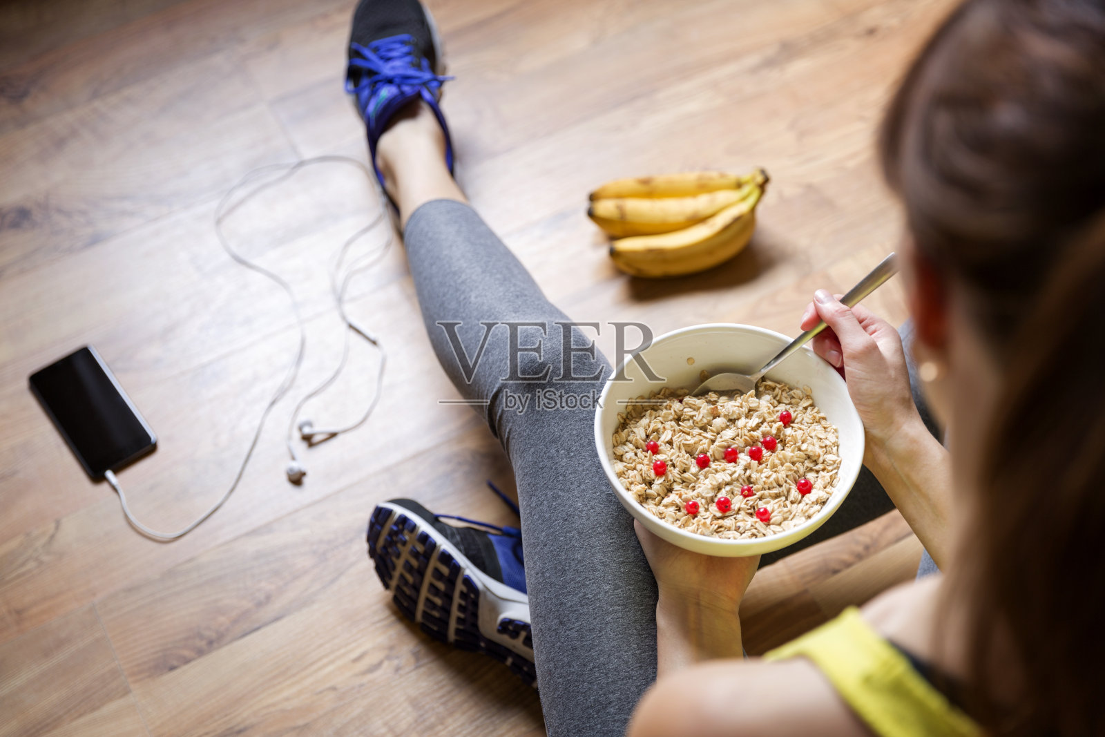 一个小女孩在锻炼后吃着浆果燕麦粥。健身和健康生活理念。照片摄影图片