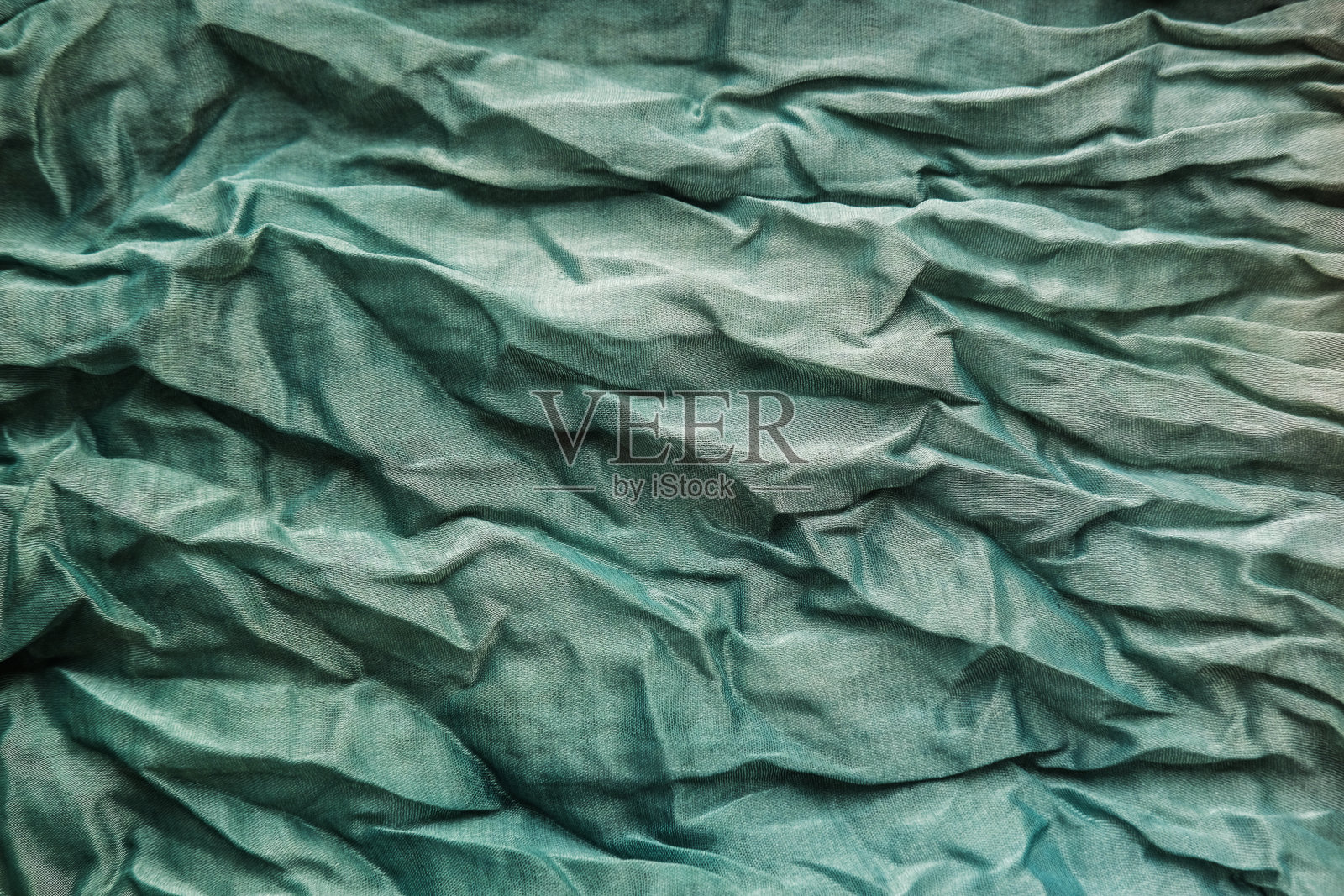 薄荷褶皱织物的质地。绿乔其面料。照片摄影图片