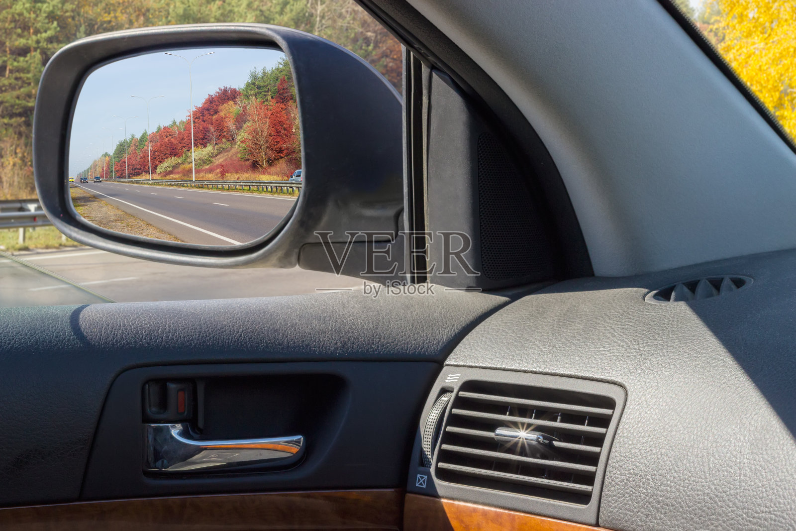 在秋天的汽车后视镜里反射高速公路照片摄影图片