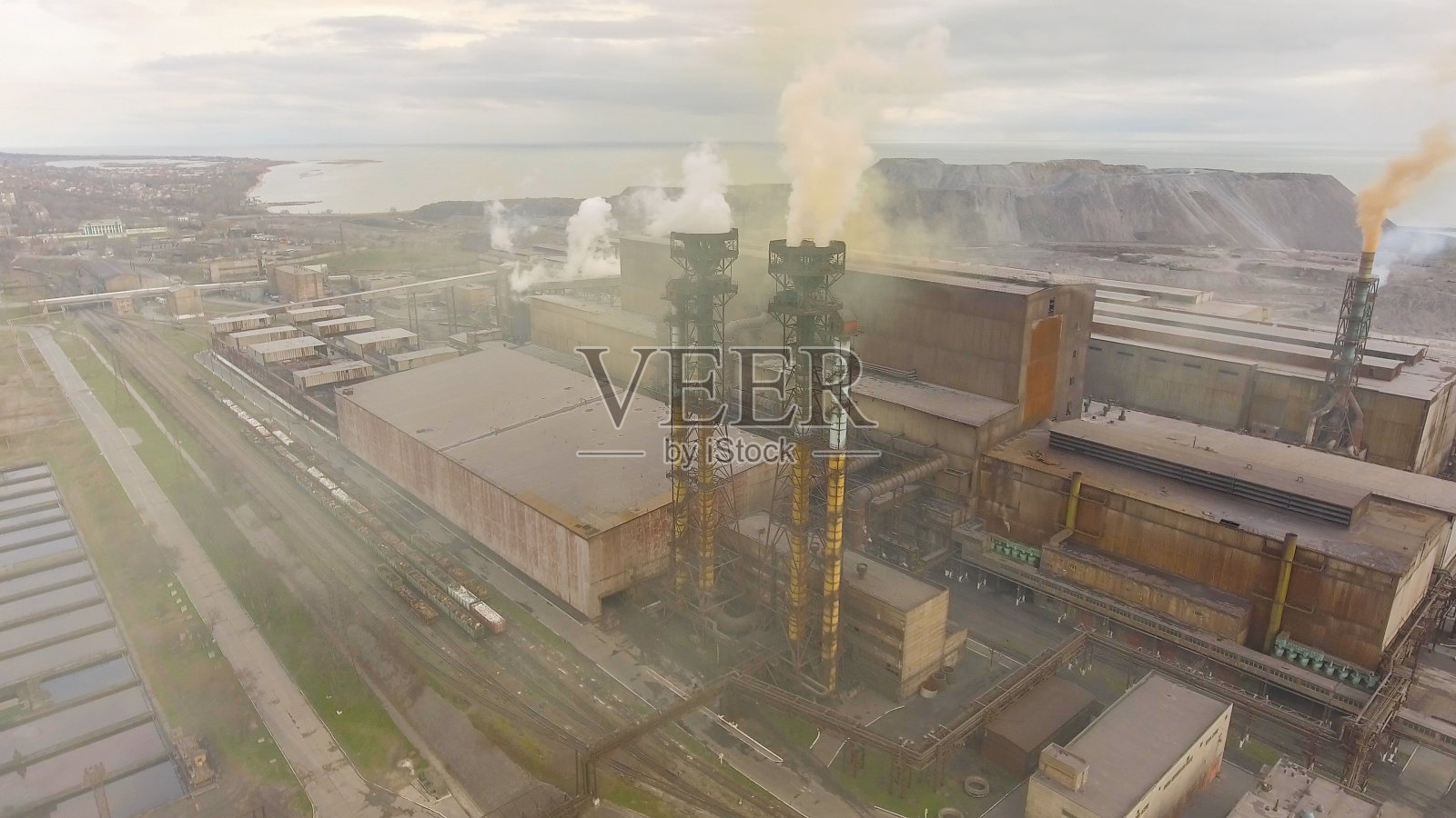 工业钢铁厂鸟瞰图。天线采用工厂。飞过烟雾缭绕的钢铁厂管道。环境污染。烟照片摄影图片