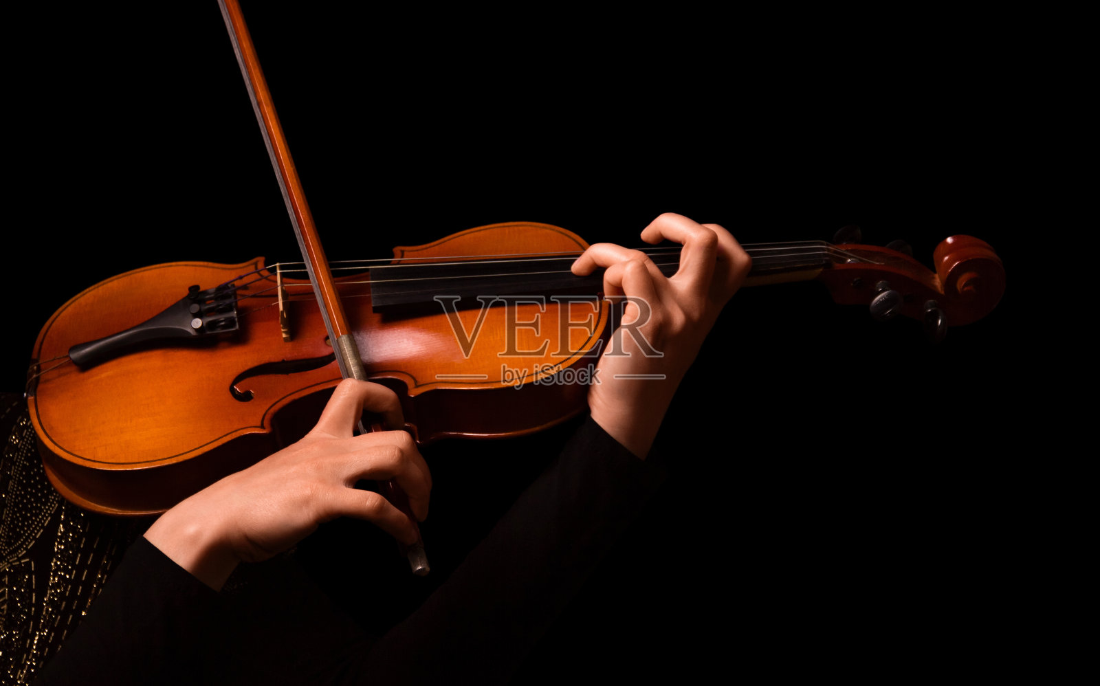 一个女人的手拉着小提琴孤立在黑色照片摄影图片