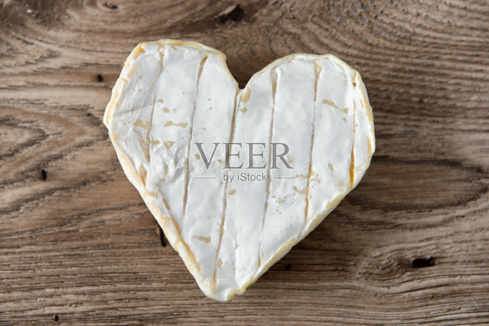 一个法国Neufchatel奶酪形状的心放在木桌上照片摄影图片
