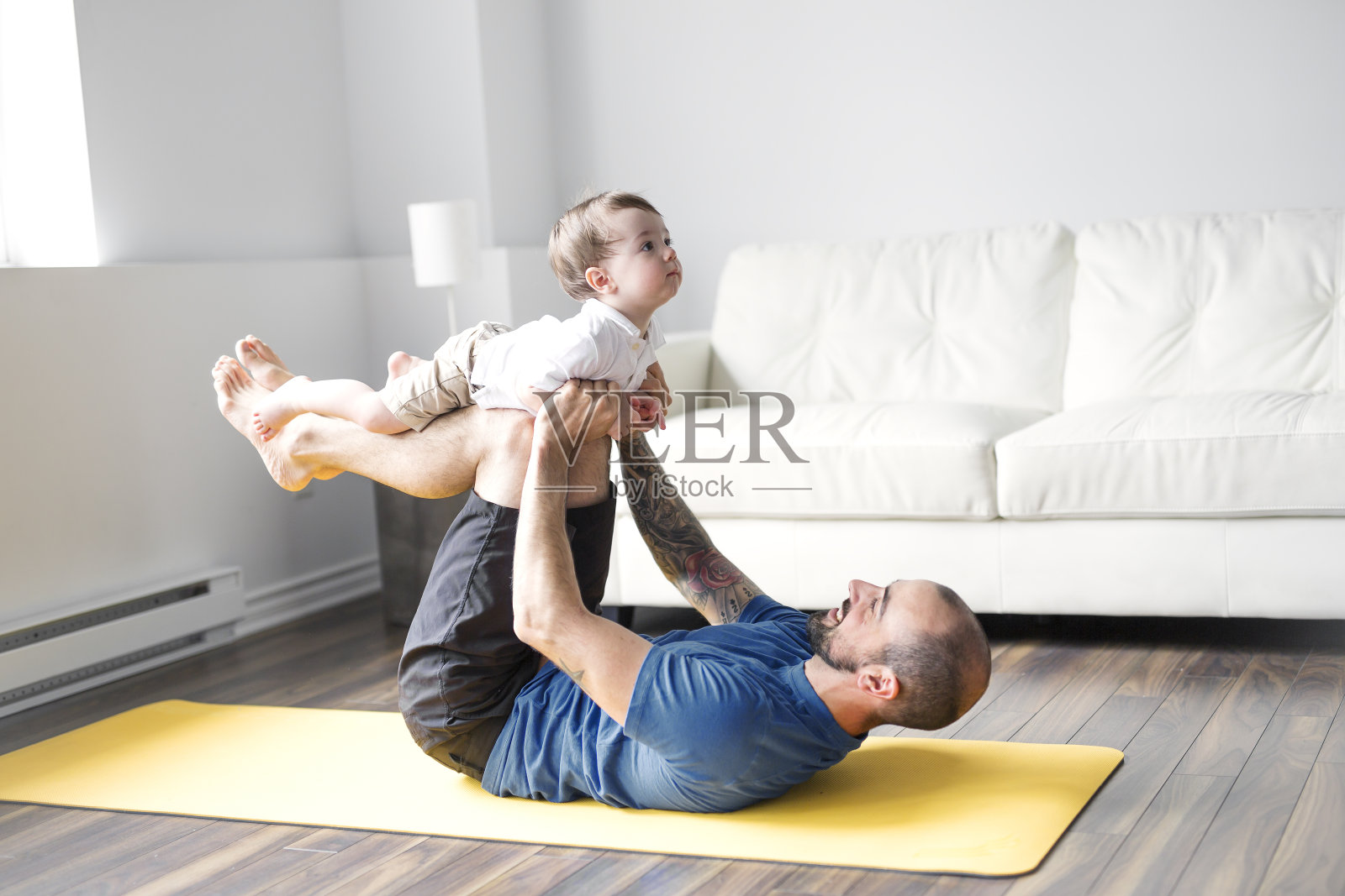 运动男士在家带着孩子进行健身和瑜伽照片摄影图片