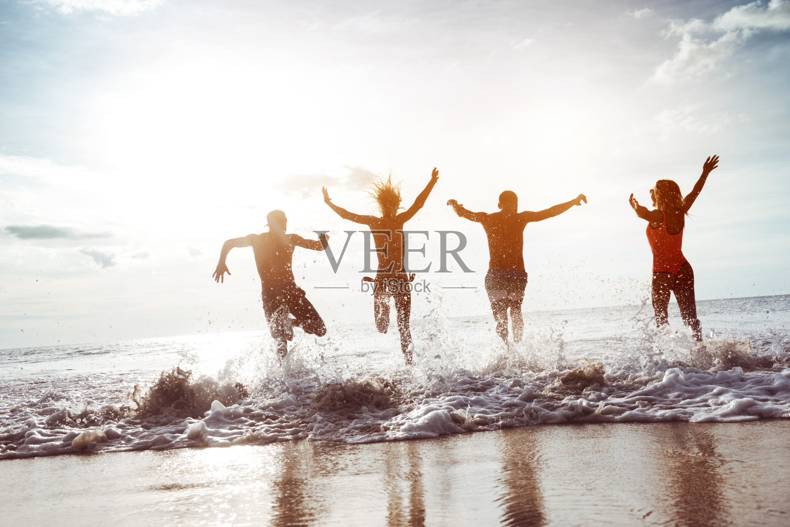四个快乐的朋友跑到日落海滩照片摄影图片
