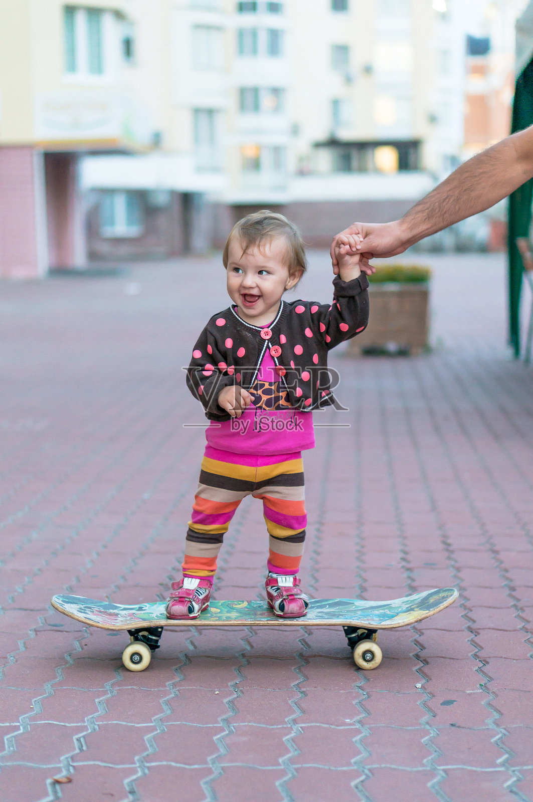 在滑板上微笑的小女孩照片摄影图片