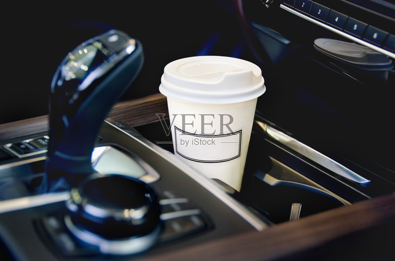 在汽车沙龙喝咖啡。汽车杯架里的一个纸咖啡杯。照片摄影图片