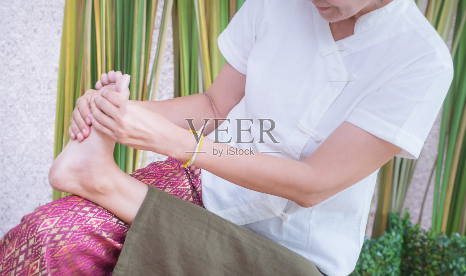 泰国按摩师正在按摩一个女人的脚在泰国温泉照片摄影图片