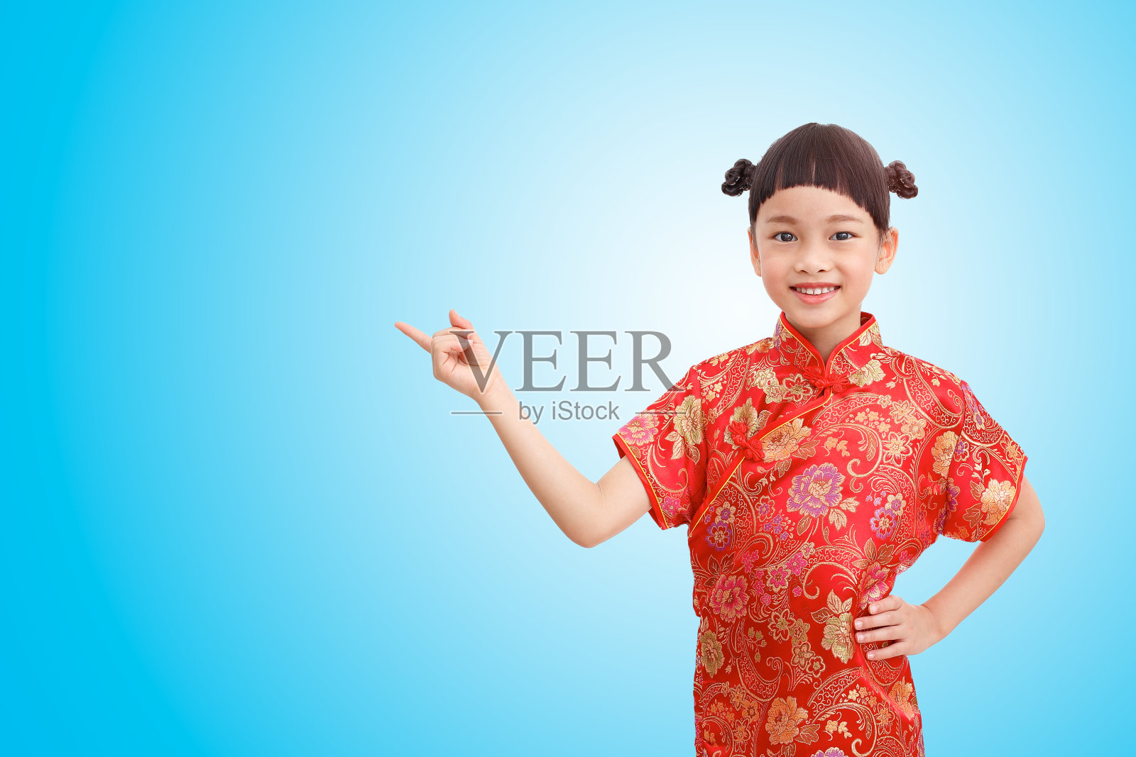 中国小指头女孩点着表演，穿着旗袍孤立在蓝色渐变背景上。剪切路径照片摄影图片