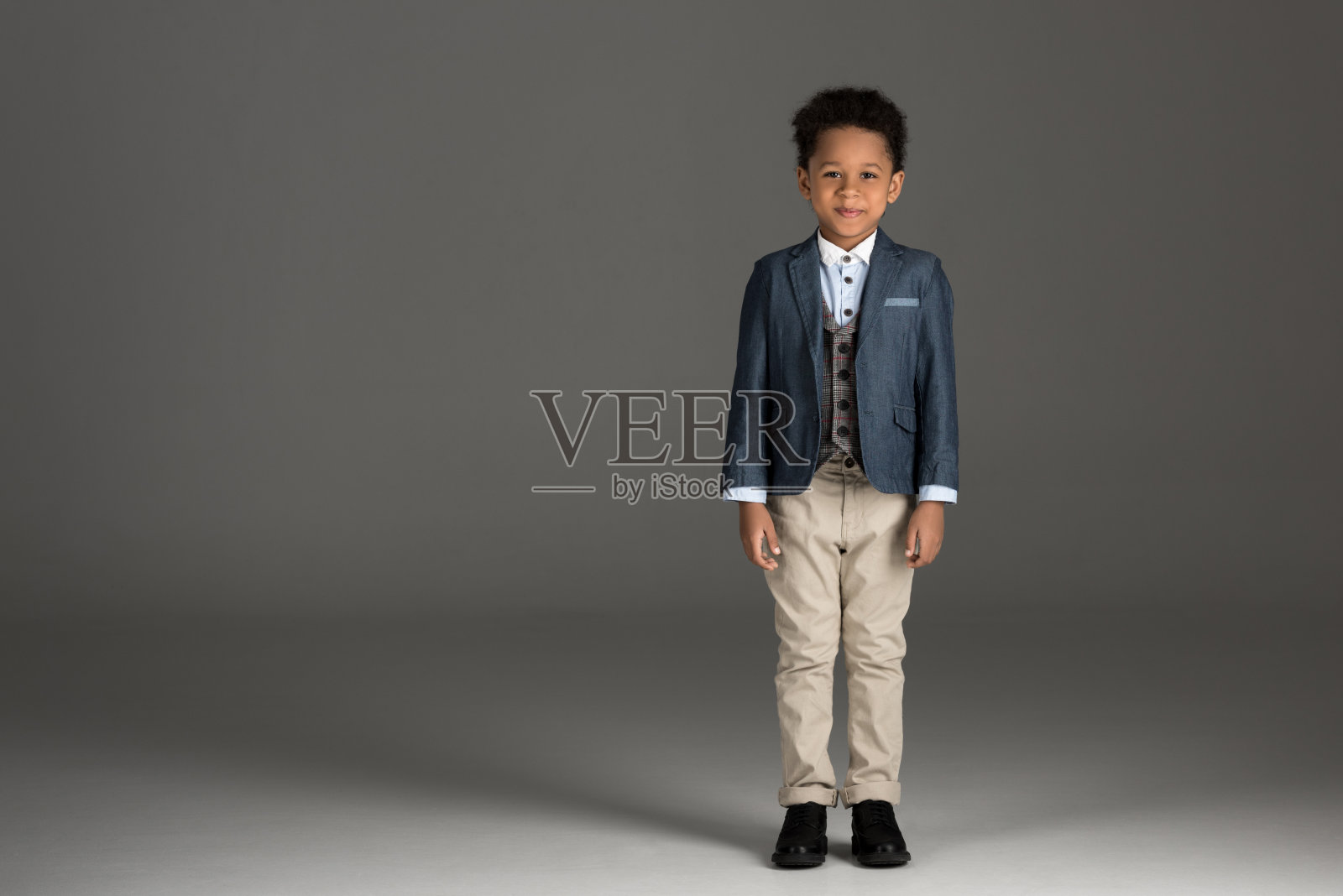 可爱的非裔美国男孩站在灰色西装照片摄影图片