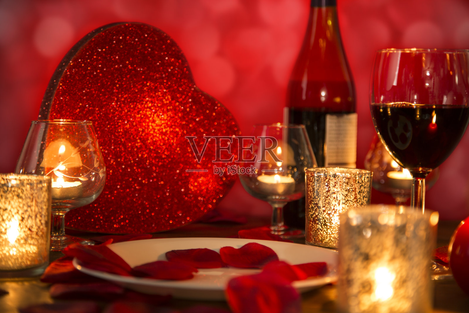 情人节浪漫的烛光晚餐，贴心的礼物和美酒。照片摄影图片