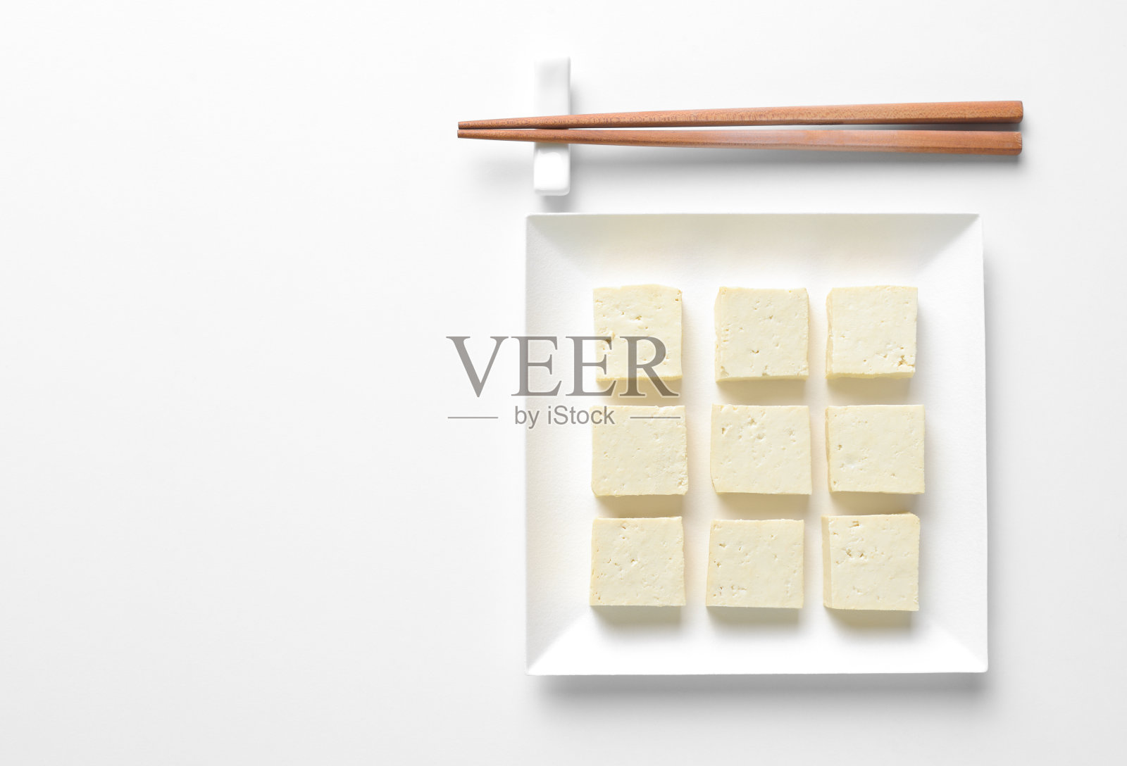 豆腐切成丁，盛在方盘子里，概念餐桌设置照片摄影图片