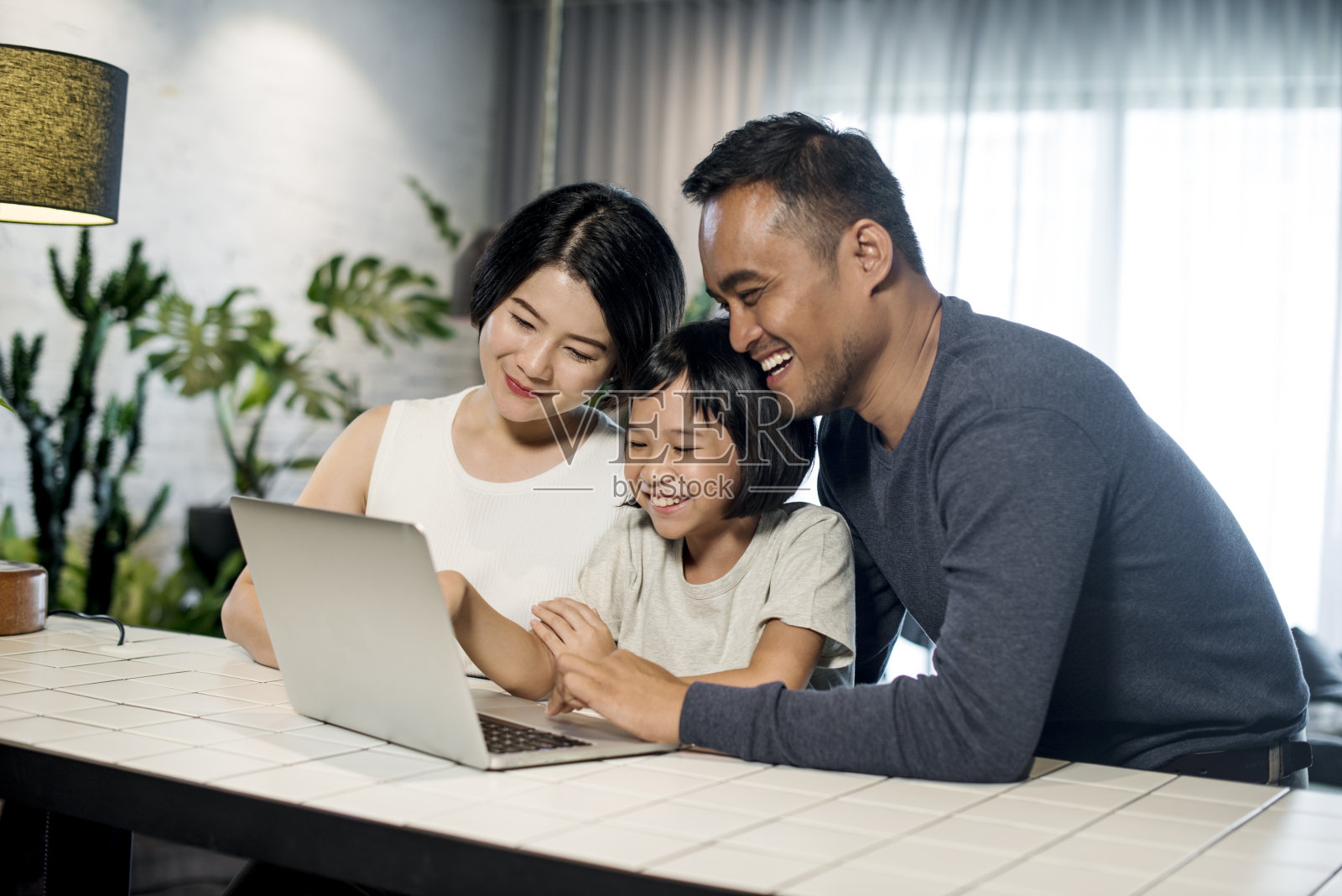 亚洲家庭一起看电脑。照片摄影图片