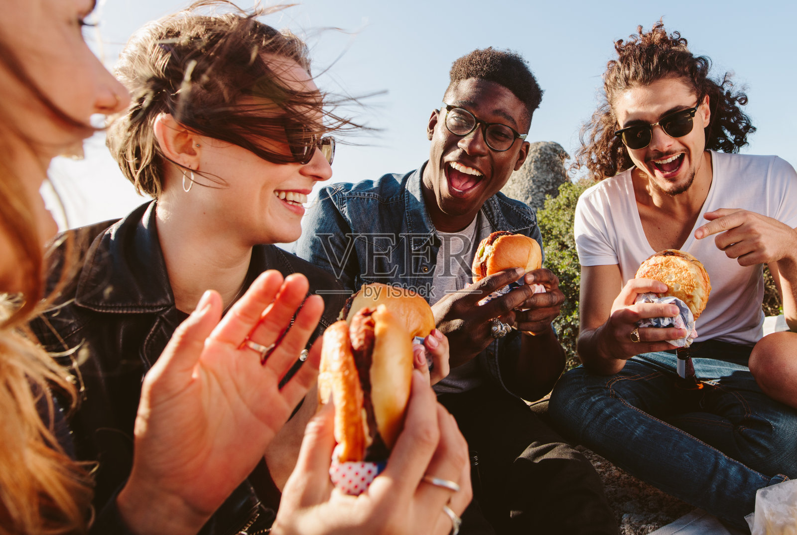 一群朋友在山顶吃汉堡照片摄影图片