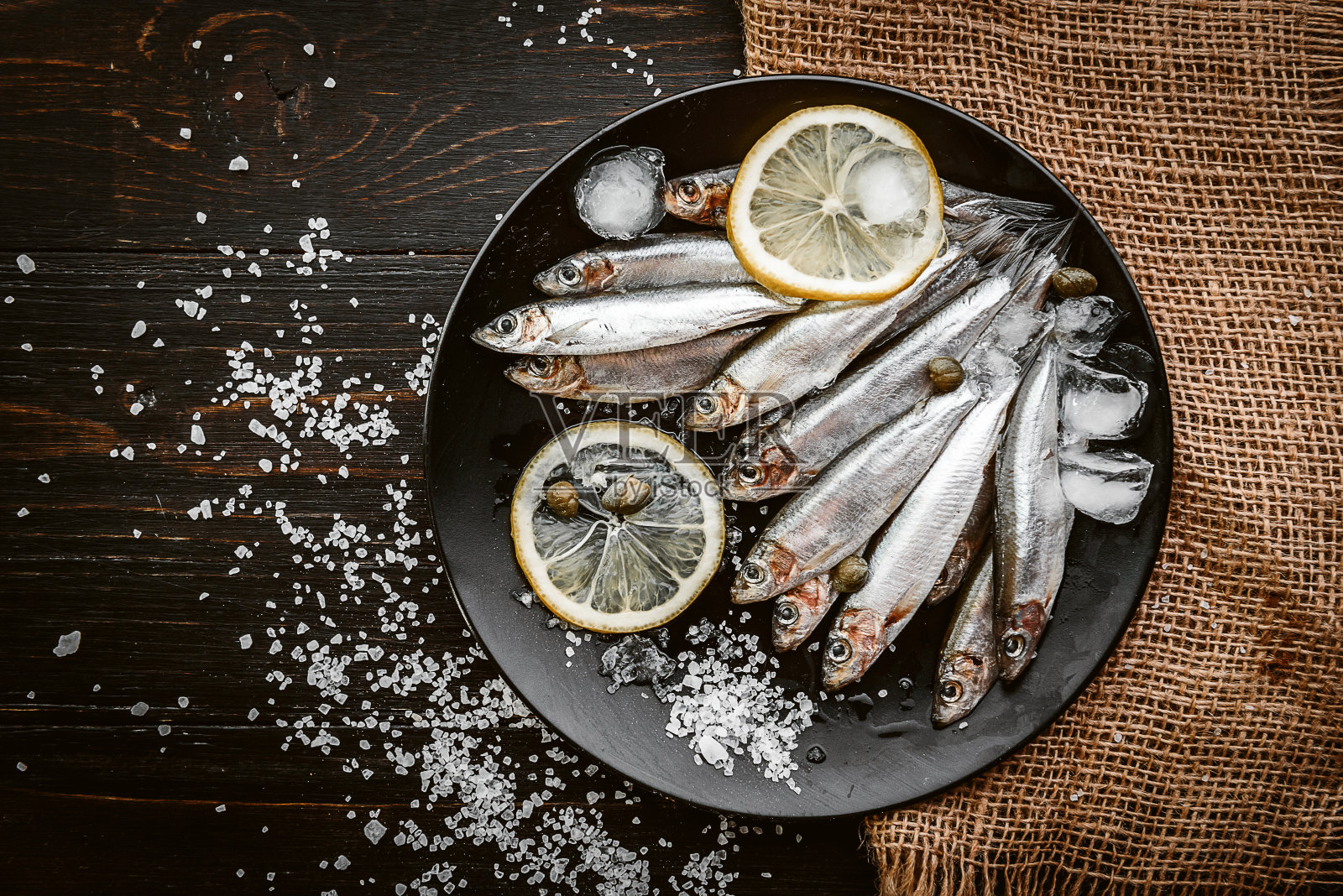 新鲜的生鱼片，配以盐和柠檬，以一种乡村风格放在木板上照片摄影图片