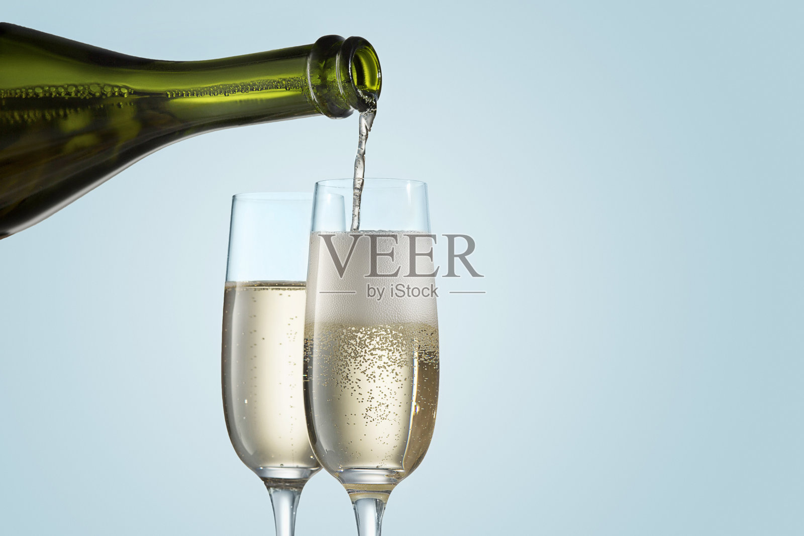 酒杯与香槟和酒瓶在闪闪发光的假日背景照片摄影图片