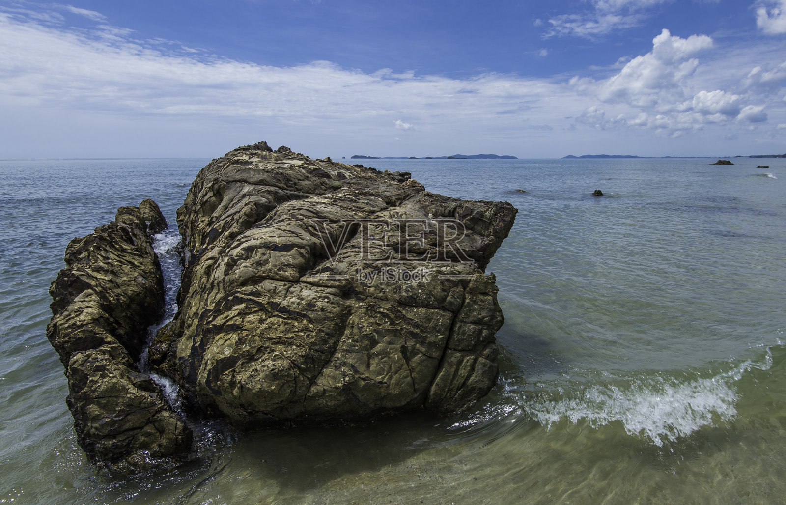 热带海滩上的岩石显示火山起源。照片摄影图片