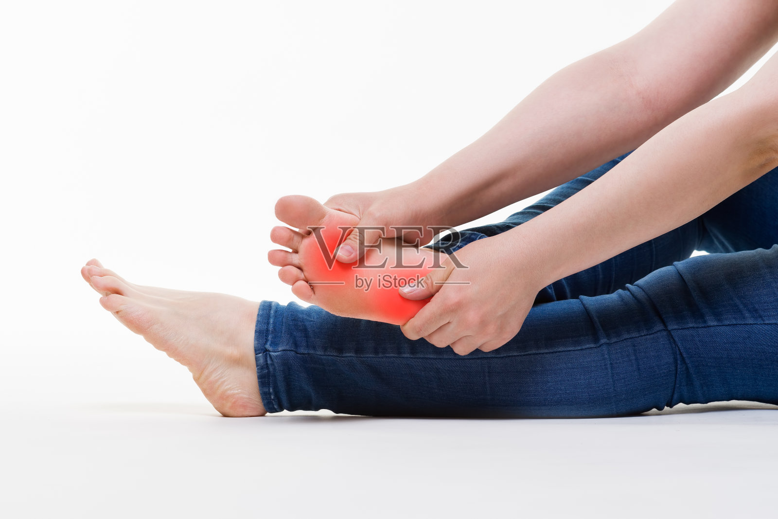 女性腿部疼痛，在白色背景上按摩女性脚部照片摄影图片