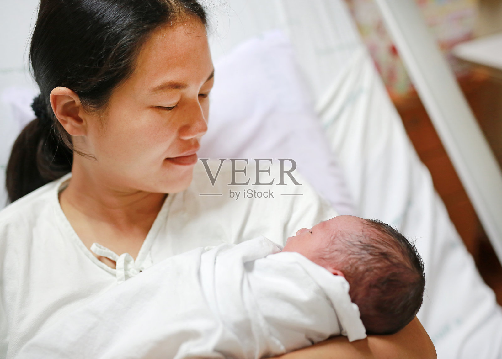 亚洲母亲在产房后在医院抱着婴儿。照片摄影图片