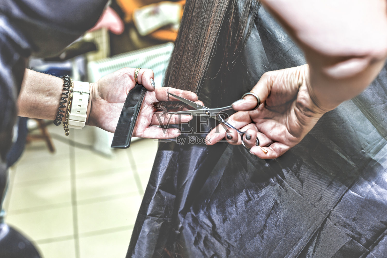 在美容院里，发型师给一位妇女剪长发照片摄影图片