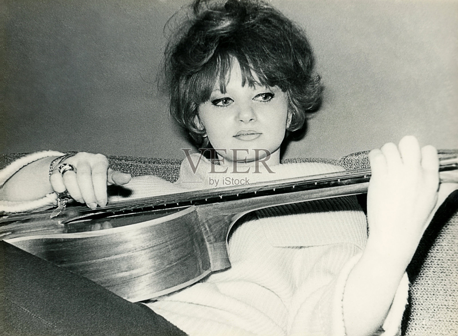 六十年代弹吉他的年轻女子照片摄影图片