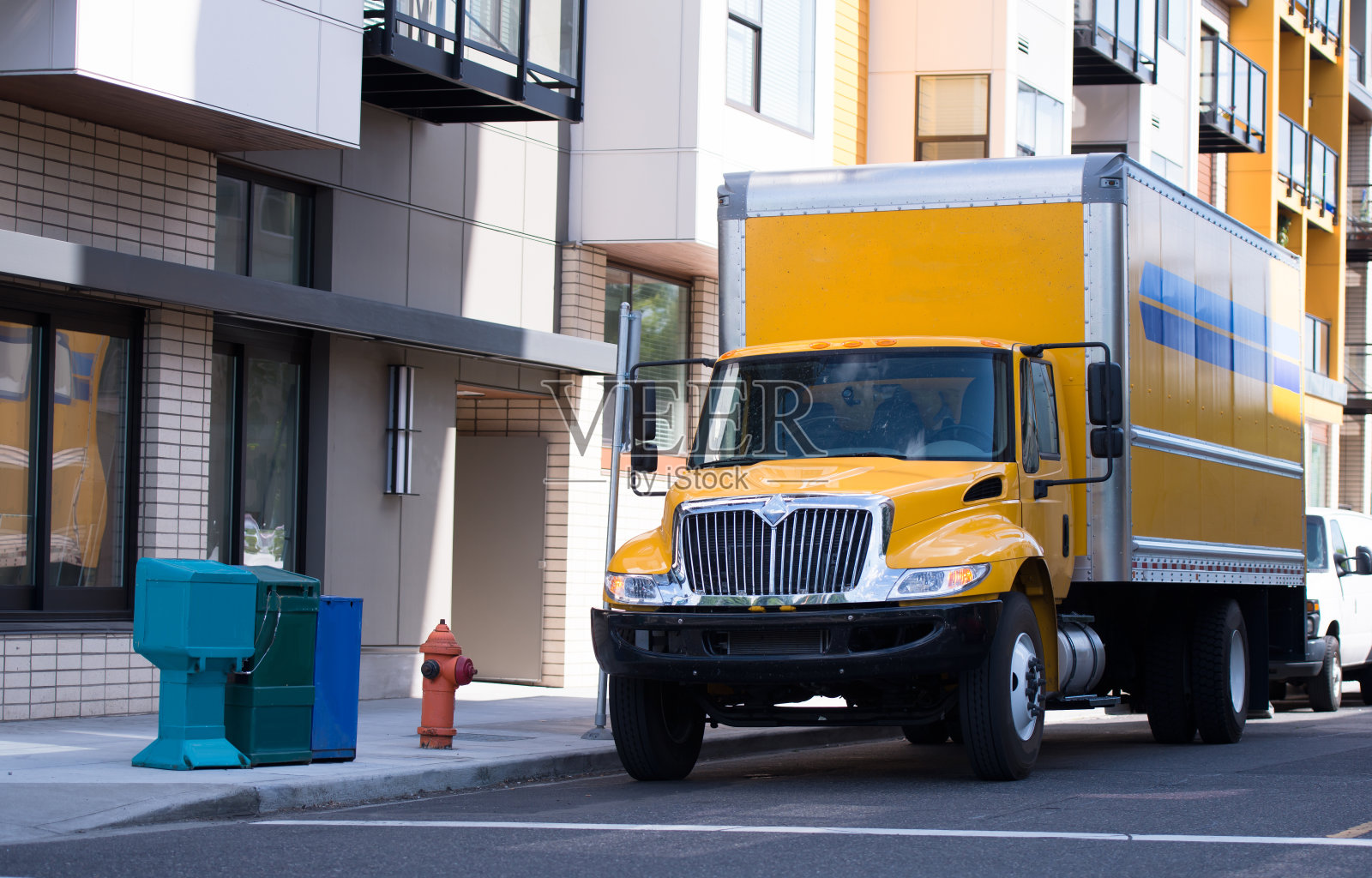 中产阶级的黄色半挂车带着拖车在城市街道上运送当地货物照片摄影图片
