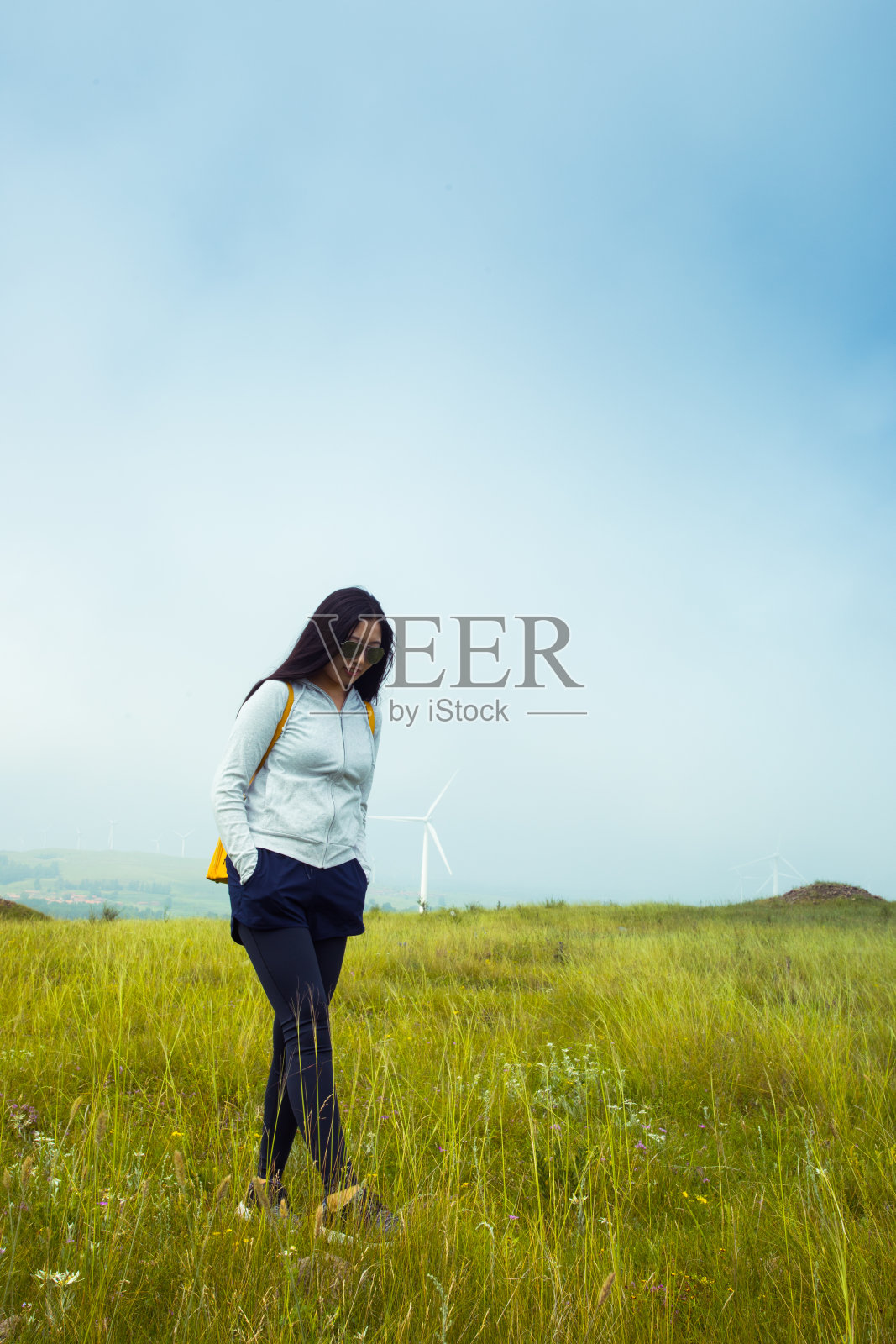 年轻女子站在大草原上照片摄影图片