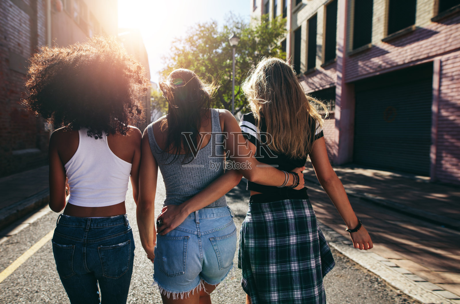 三个年轻女人一起走在城市的街道上照片摄影图片