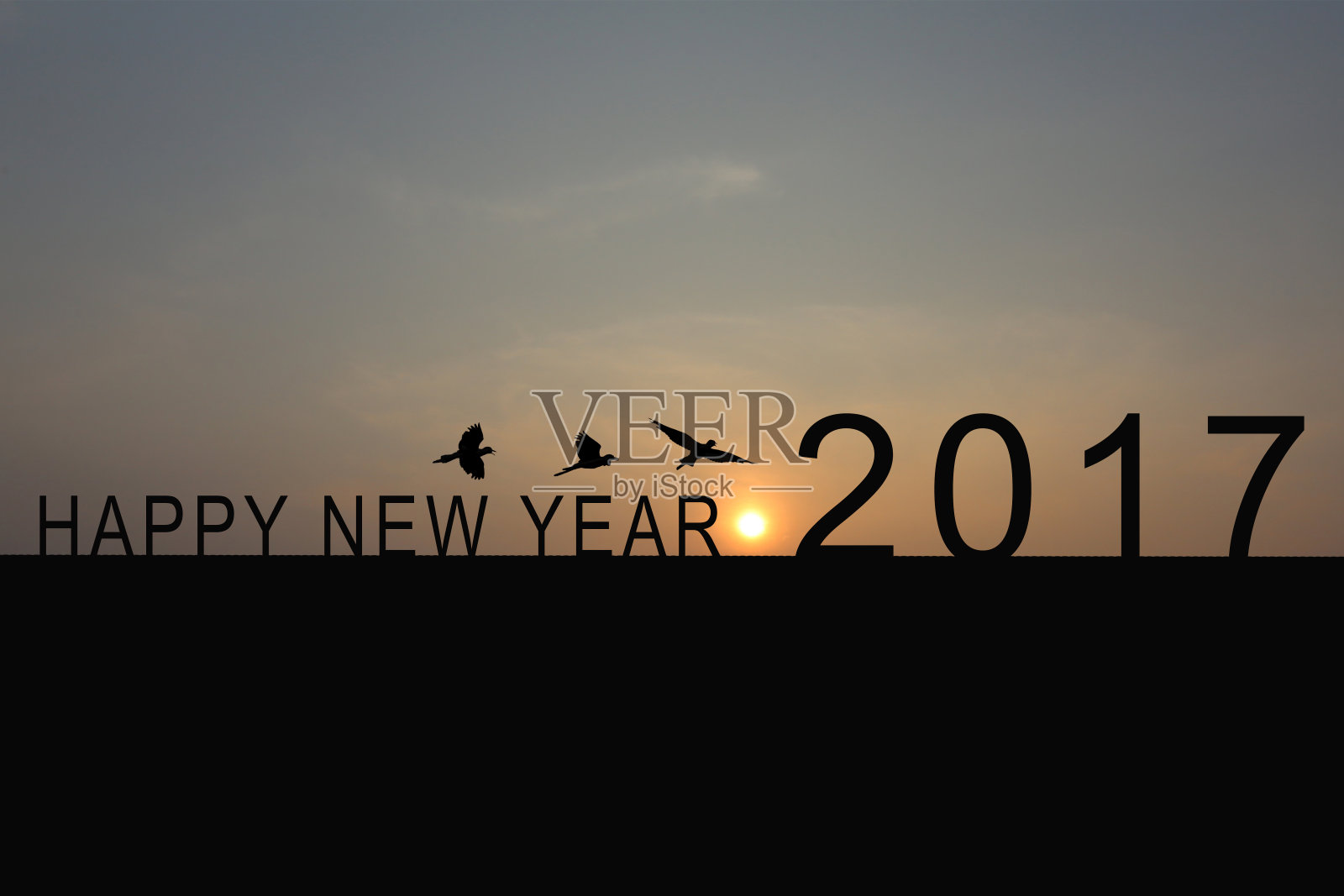 屋顶上数字2017的剪影和黄昏天空中的日出，新年和圣诞节的概念。照片摄影图片
