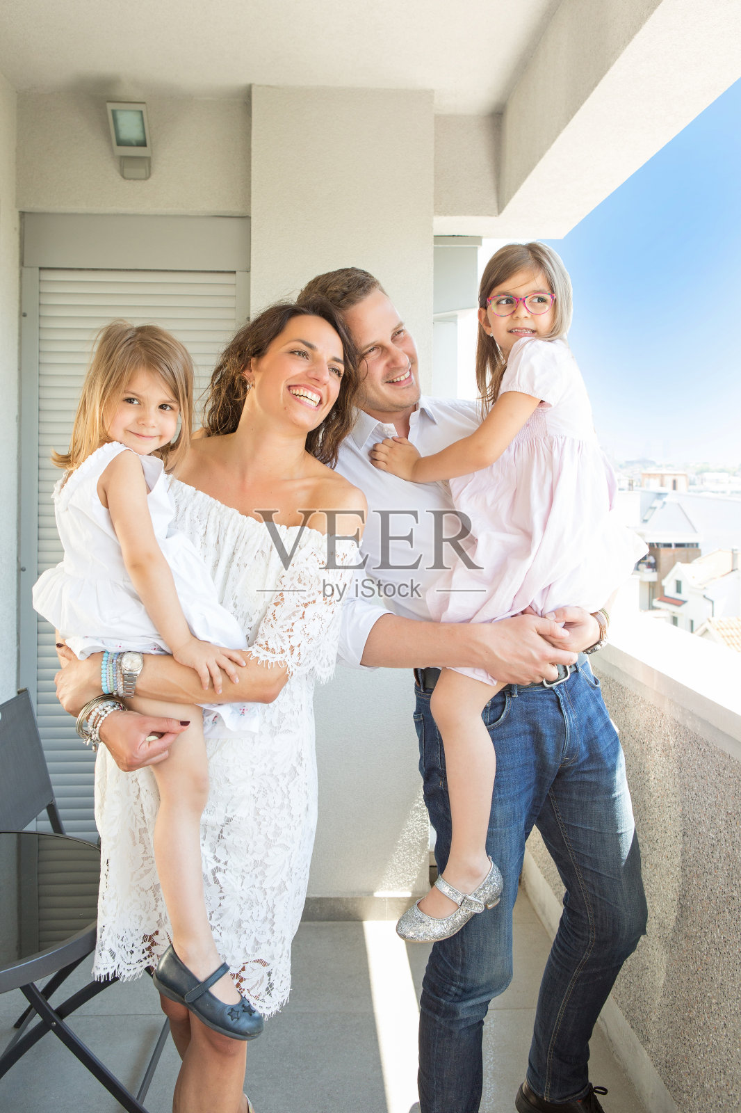 幸福的一家人站在公寓、酒店、阳台上照片摄影图片