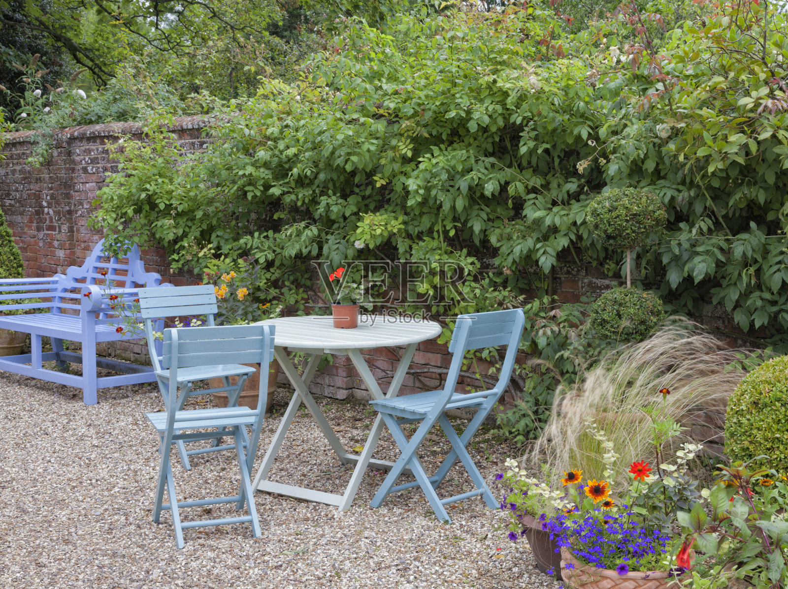 蓝色的花园家具在一个小花园。照片摄影图片