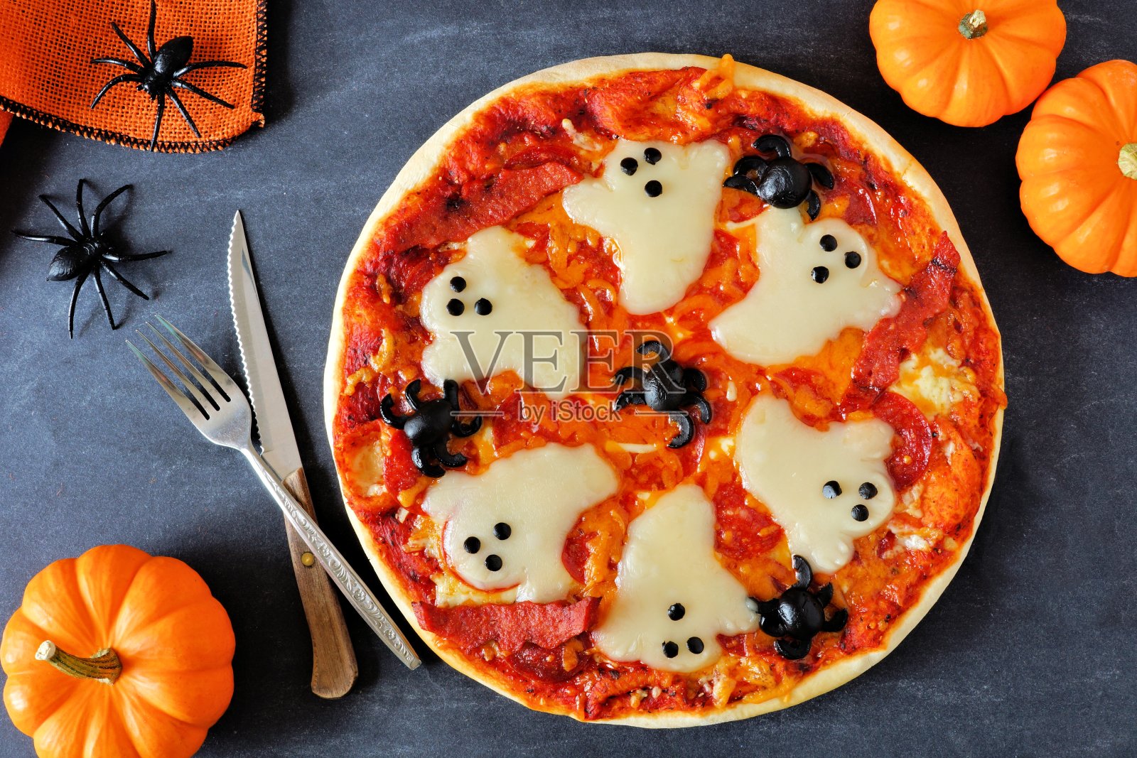 万圣节披萨，上面的场景与装饰在黑色的背景照片摄影图片
