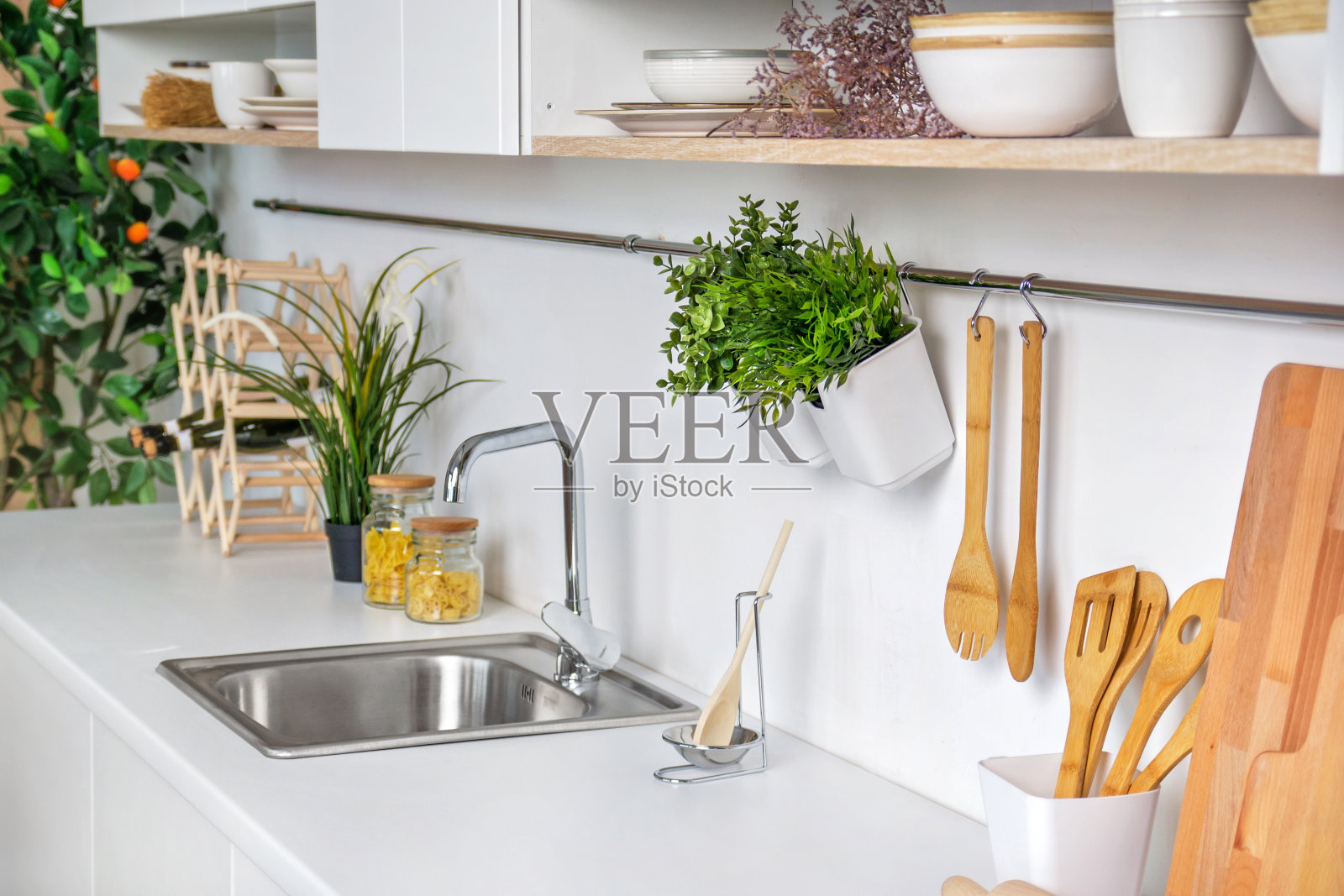 现代白色厨房的内部特写，以木制厨具和橘子树为背景照片摄影图片