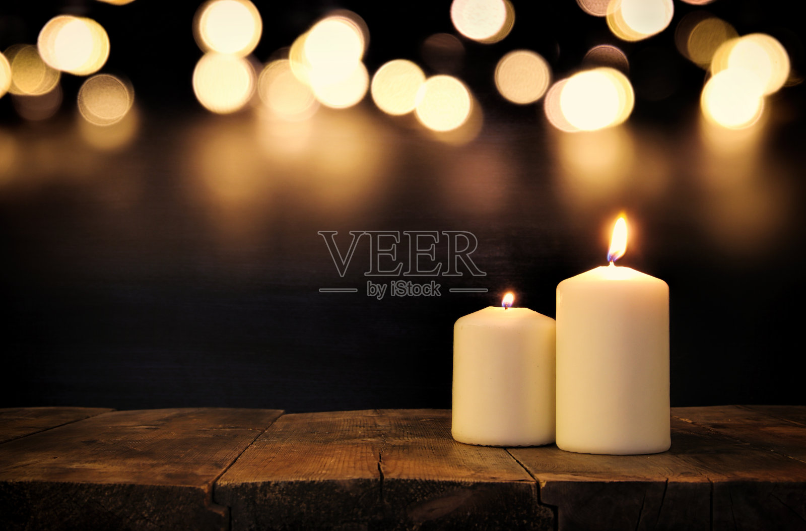 在旧木桌上点着蜡烛，配上白焦灯照片摄影图片