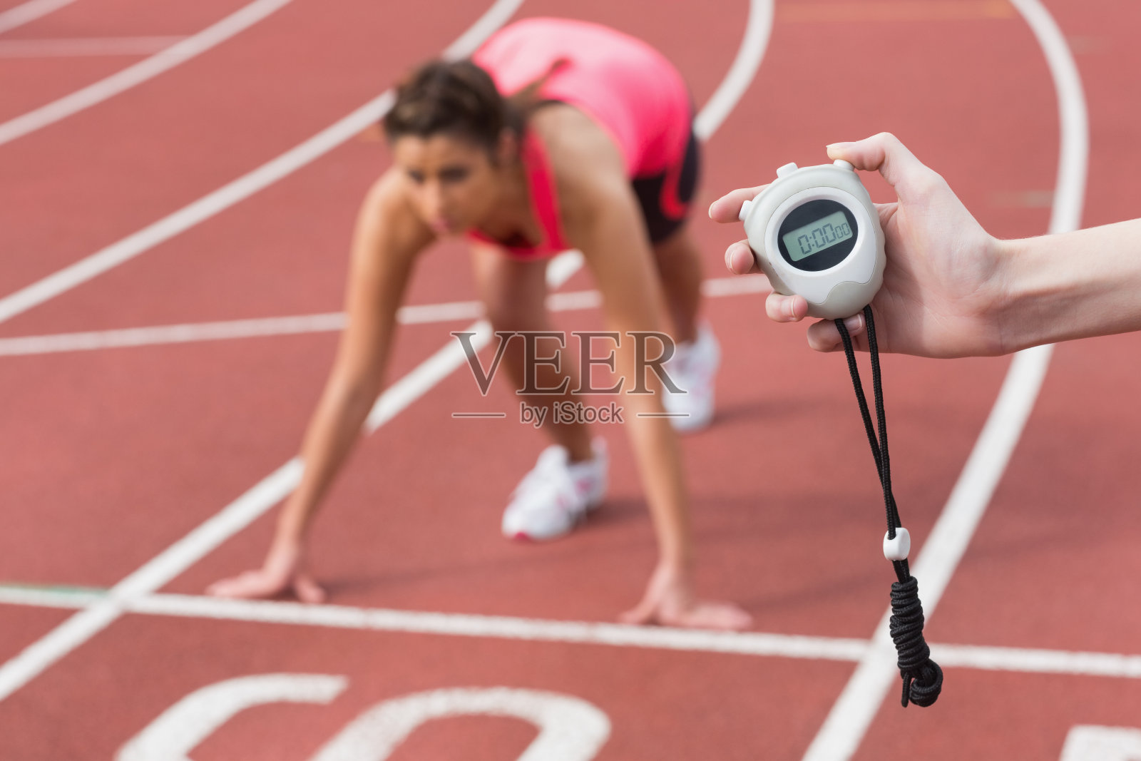 手计时一个女人跑在跑道上照片摄影图片