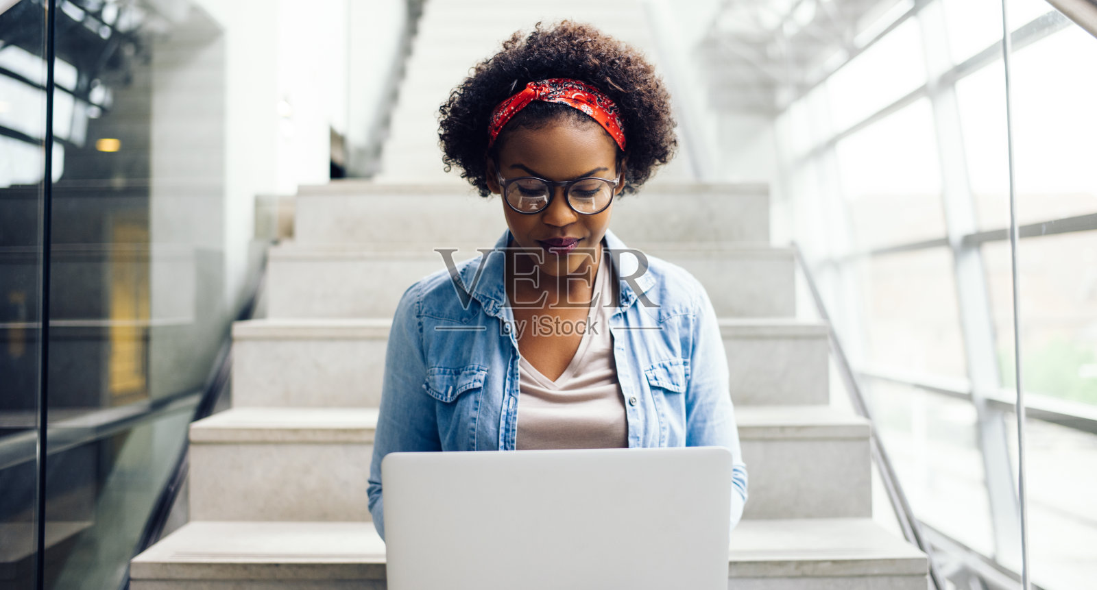 专注的年轻非洲学生坐在楼梯上使用笔记本电脑照片摄影图片