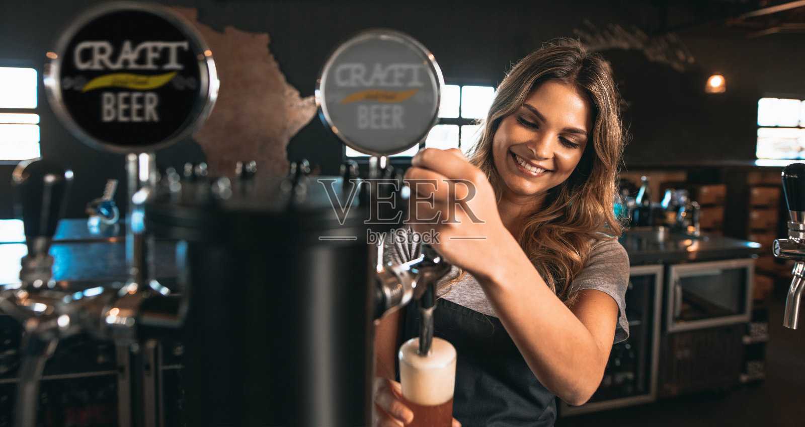 女酒保在酒吧里喝精酿啤酒照片摄影图片