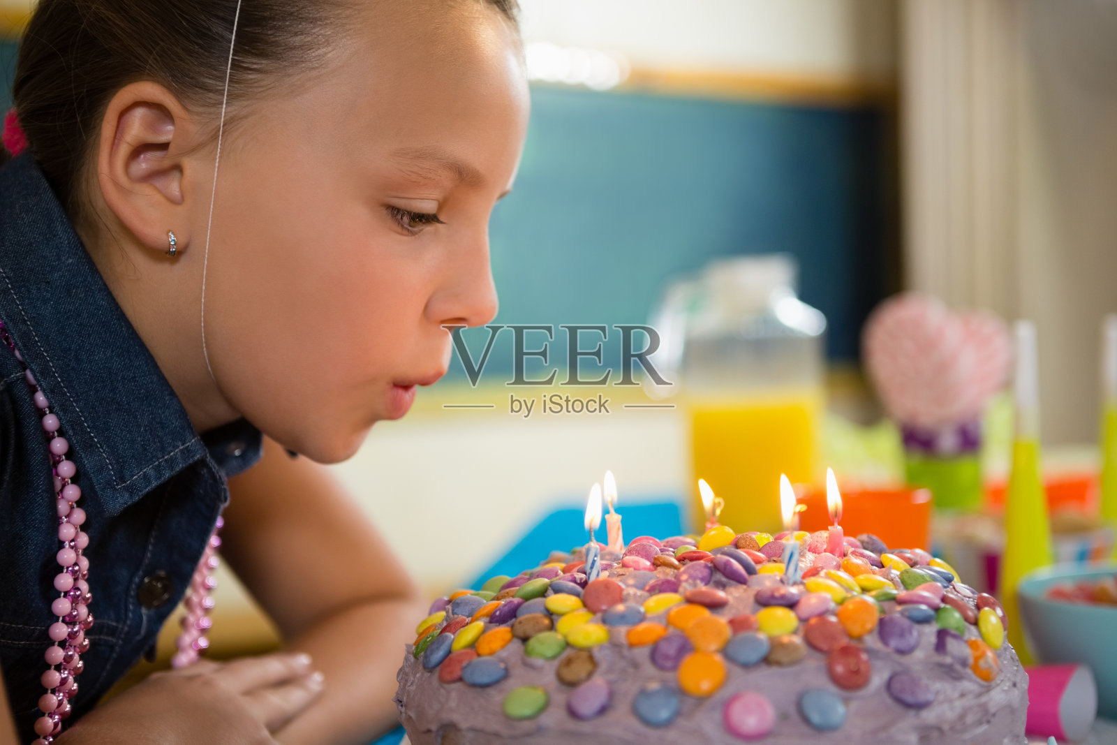 女孩吹灭生日蛋糕上的蜡烛照片摄影图片