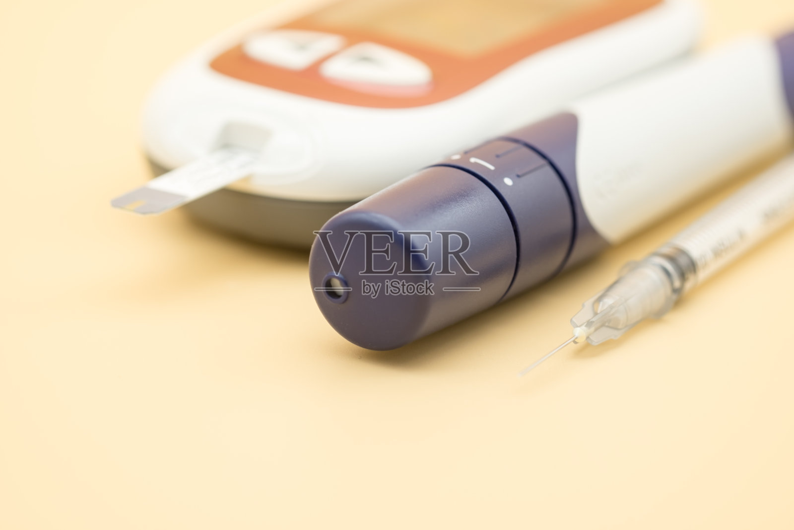 胰岛素注射器和血糖仪的关闭与柳叶刀检查血糖水平橙色背景作为药物，糖尿病，血糖，保健和人的概念照片摄影图片