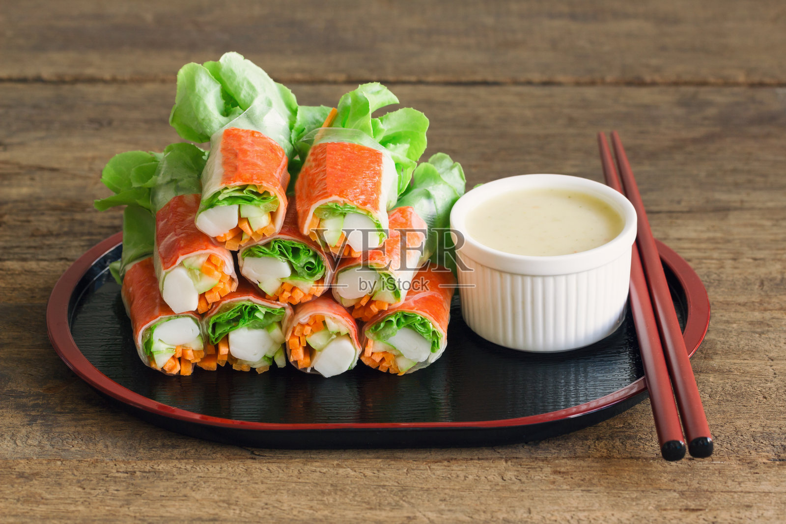 新鲜的春卷，新鲜的蔬菜，蟹肉条，芥末混合沙拉奶油蘸酱。日式沙拉卷或新鲜春卷，健康美味的开胃菜或正餐。照片摄影图片